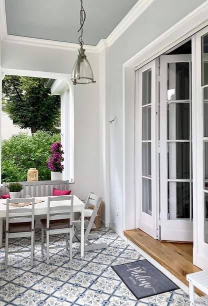 Veranda mit wunderschönen Zementfliesen und individueller Fußmatte in Grau