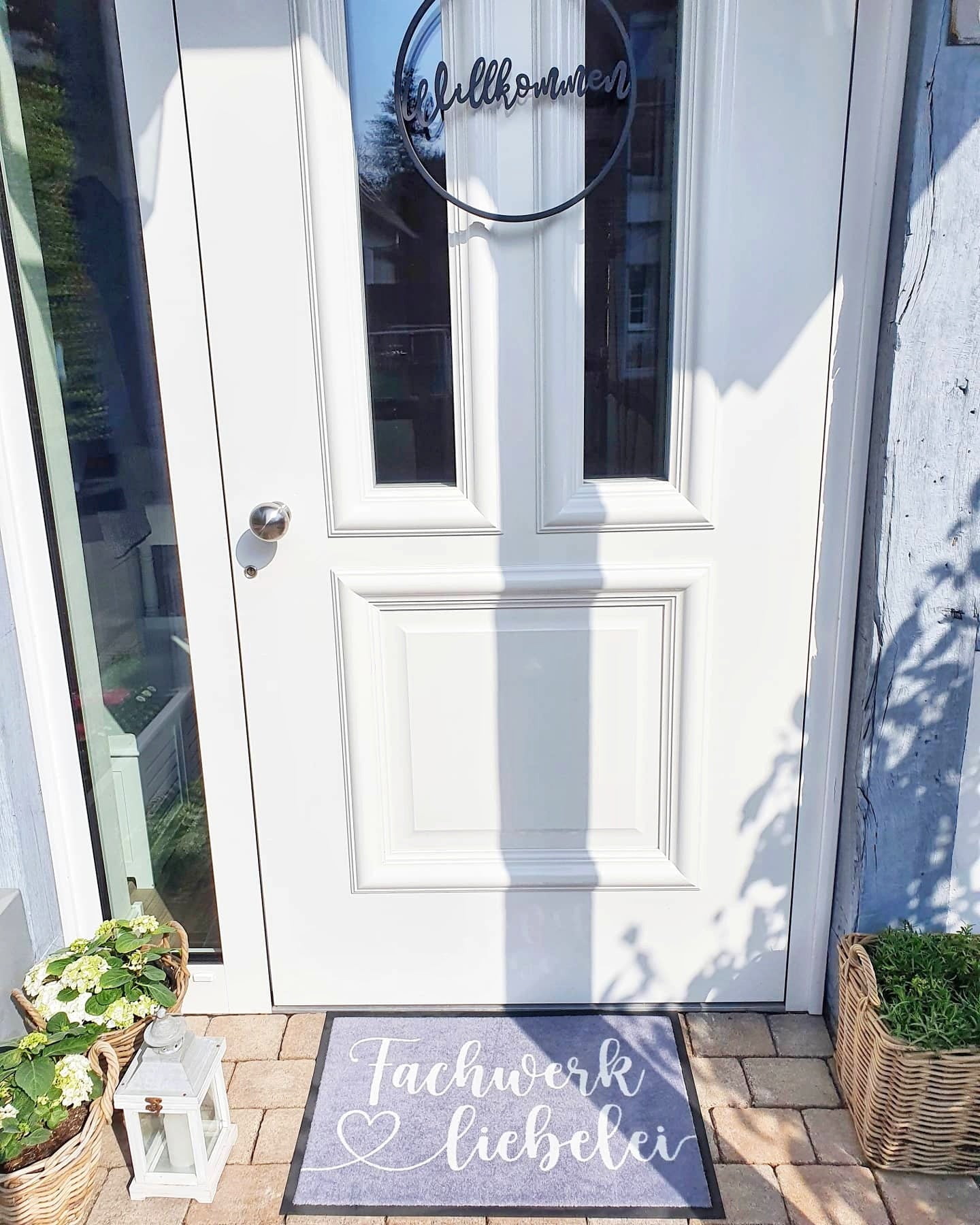personalisierte Fußmatte in grau vor weißer Haustür